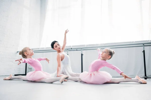 young ballet teacher training cute little ballerinas in ballet studio