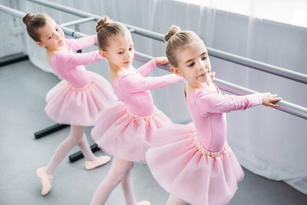 high angle view of elegant little ballerinas dancing in ballet school