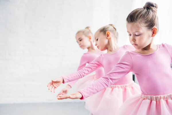 beautiful little kids in pink clothing dancing in ballet studio