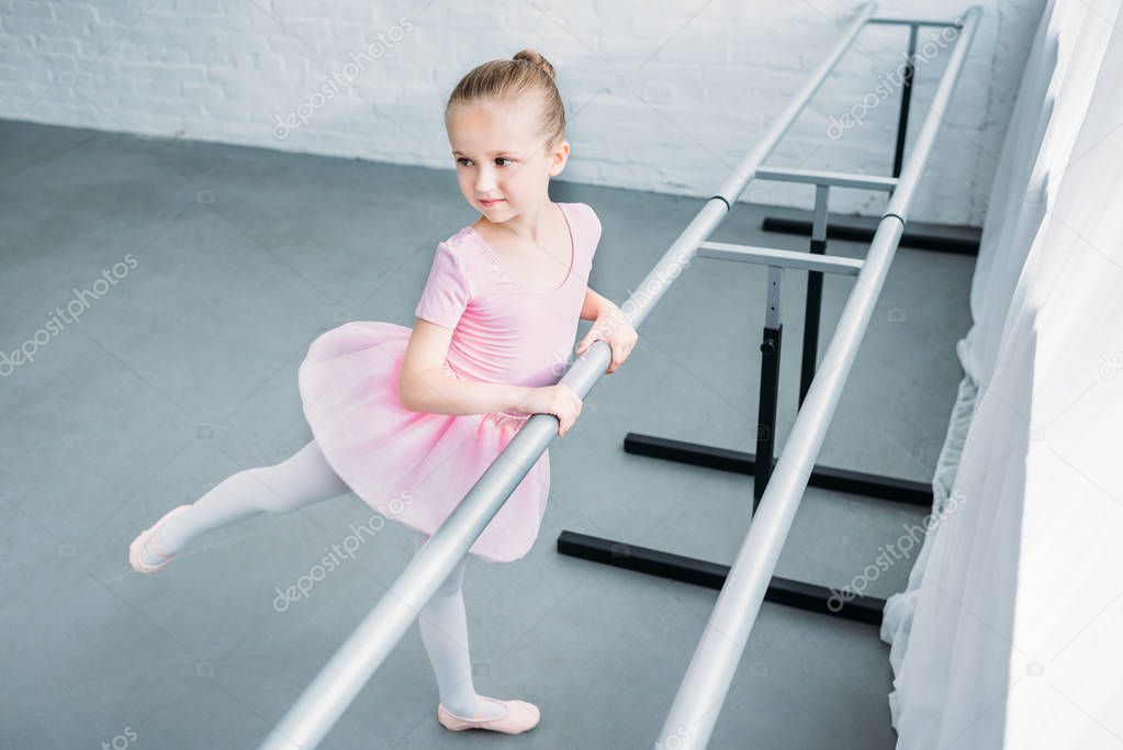 high angle view of adorable child practicing ballet in studio