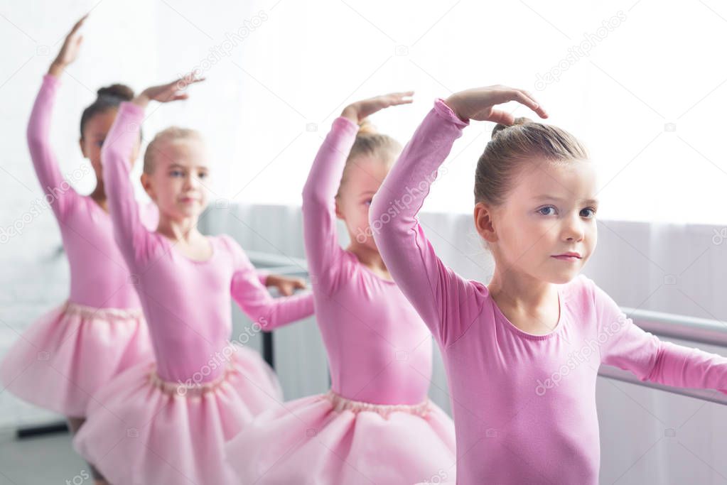 beautiful kids in pink tutu skirts dancing in ballet school