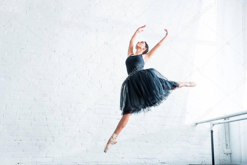 low angle view of beautiful young ballerina dancing in ballet studio