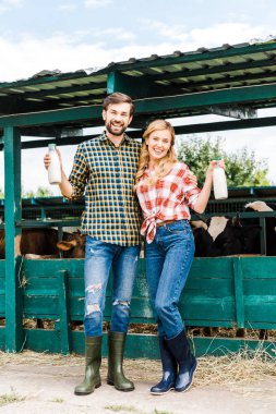 inek sütü şişe istikrarlı tutarak ve kameraya bakarak çiftçiler birkaç