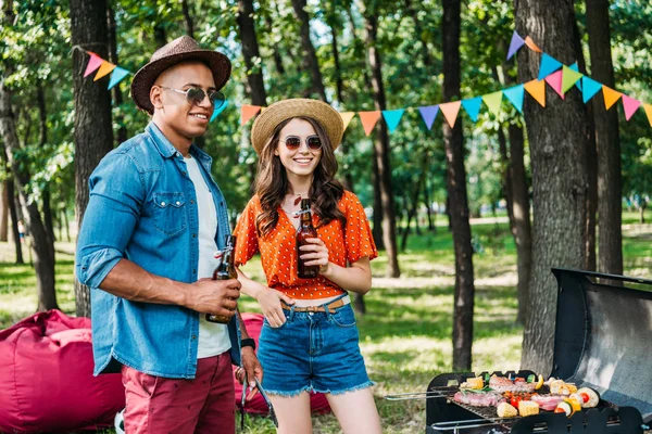 Sonriente Interracial Joven Pareja Con Cerveza Pie Cerca Parrilla Verano — Foto de Stock