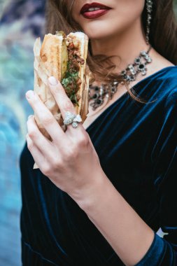kısmi görünümü içinde şık giyim sosisli sandviç Caddesi üzerinde elinde tutan kadın
