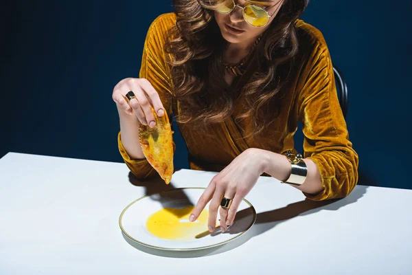 Fashionable Woman Unhealthy Meat Pastry Sitting Table Blue Backdrop — Stock Photo, Image