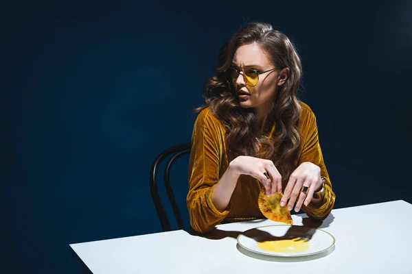 Fashionable Woman Unhealthy Meat Pastry Sitting Table Blue Backdrop — Free Stock Photo