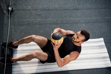 yakışıklı sporcu sit yapıyor görünümünü yüksek açı ups ile sağlık topu yoga mat çatı üzerinde