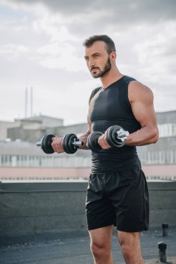 yakışıklı sporcu çatıda dumbbells ile eğitim 