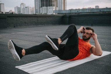 yakışıklı sporcu Sit yapıyor ups yoga mat çatı üzerinde