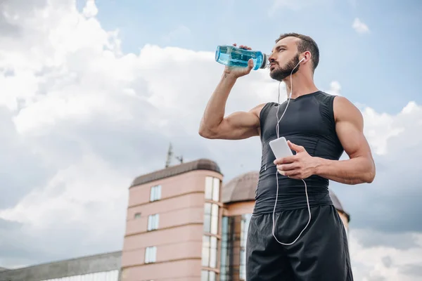 Vista Ángulo Bajo Deportista Guapo Escuchando Música Con Teléfono Inteligente — Foto de Stock