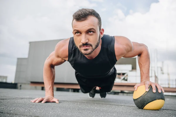 Όμορφος Μυϊκή Αθλητής Κάνει Push Ups Ιατρική Μπάλα Στη Στέγη — Φωτογραφία Αρχείου