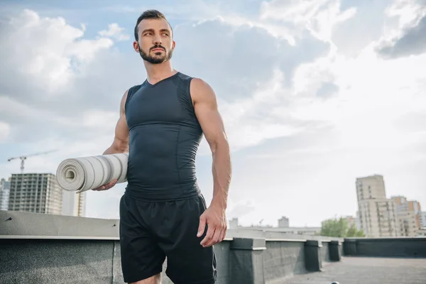 Yakışıklı Adam Çatıda Yoga Mat Ile Ayakta — Stok fotoğraf