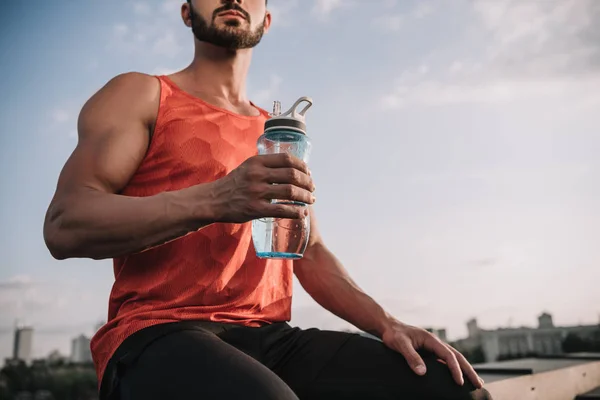 Abgeschnittenes Bild Eines Sportlers Der Eine Wasserflasche Auf Dem Dach — kostenloses Stockfoto