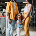年轻的非洲裔美国人的父母与小女儿在杂货店里