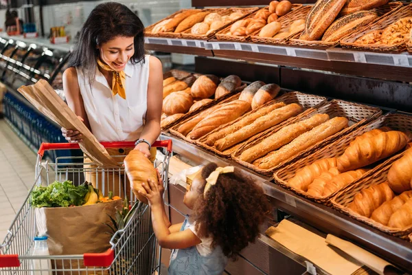 Uśmiechający Się African American Kobieta Daje Chleb Małego Dziecka Supermarkecie — Zdjęcie stockowe