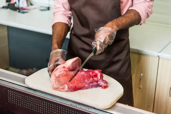 Imagem Cortada Açougueiro Afro Americano Avental Cortando Carne Crua Supermercado — Fotografia de Stock