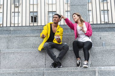 el tarafından karışık yarış erkek şehir sokak, parmakla burger ile çekici Asyalı kadın