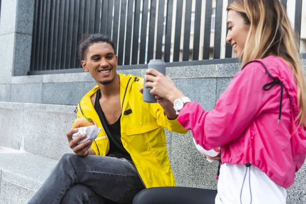 Happy Multicultural Couple Burgers Clinking Soda Drinks City Street — Free Stock Photo