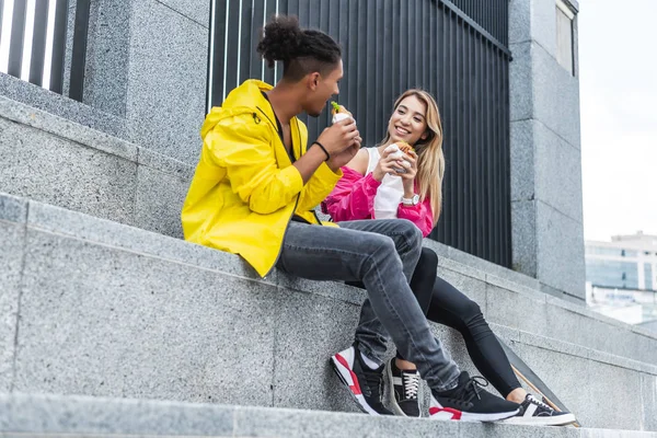 Smiling Multicultural Couple Eating Burgers Skateboard City Street — Stock Photo, Image
