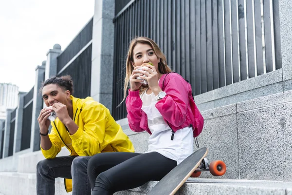 Selective Focus Multicultural Couple Eating Burgers Skateboard City Street — Stock Photo, Image
