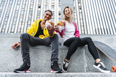 çok ırklı birkaç Burger City sokak gösterilen kaykaycılar gülümseyen, düşük açılı görünüş
