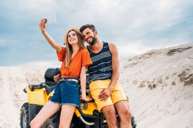 çölde Atv alma selfie ile mutlu genç çift