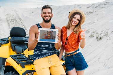 atv dijital tablet couchsurfing website ekran ve başparmak ile çöl göstermek yukarıya ile güzel genç çift