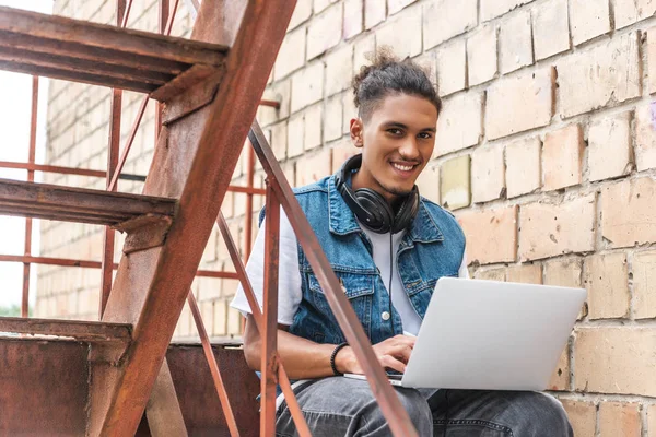 Sorrindo Raça Mista Masculino Freelancer Fones Ouvido Trabalhando Com Laptop — Fotos gratuitas