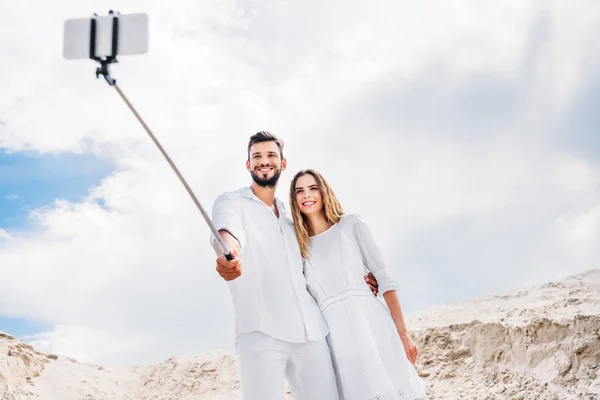 Feliz Joven Pareja Tomando Selfie Con Monopod Smartphone Desierto — Foto de stock gratis