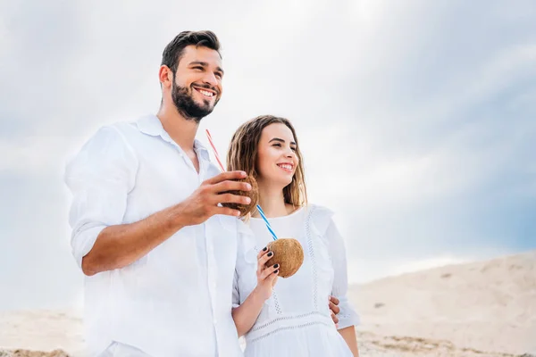 Beautiful Young Couple White Coconut Cocktails Looking Away — Free Stock Photo