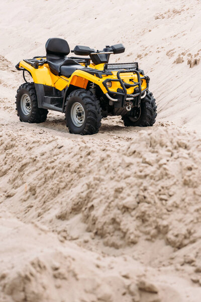 modern yellow all-terrain vehicle standing in desert