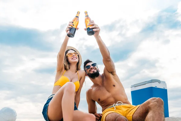 Bottom View Beautiful Young Couple Raising Bottles Beer Front Cloudy — Stock Photo, Image