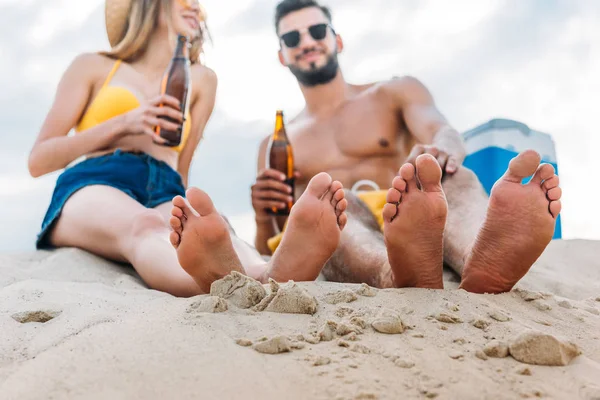 Onderaanzicht Van Jong Koppel Met Flessen Bier Zittend Zand — Stockfoto