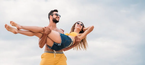 Jovem Bonito Carregando Sua Namorada Frente Céu Nublado — Fotografia de Stock