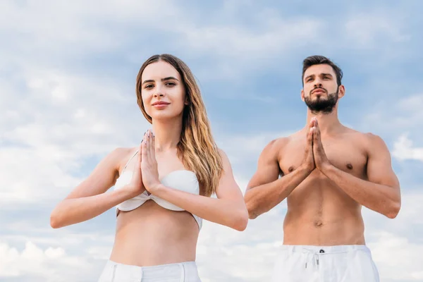 Ungt Par Gör Namaste Mudra Och Öva Yoga Framför Molnig — Gratis stockfoto