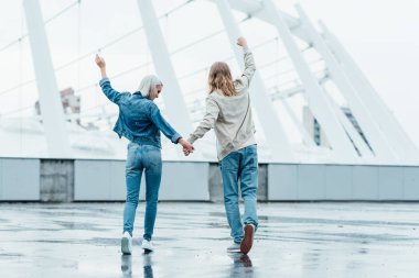 Dikiz elele ve bulutlu gün sokakta yumruk yükselterek genç çift