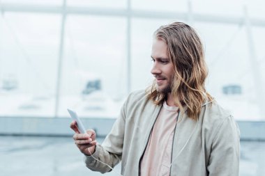 bulutlu gün sokakta Smartphone kullanarak yakışıklı genç