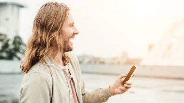 mutlu genç adam sokakta Smartphone kullanarak