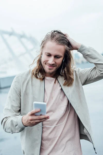 Heureux Jeune Homme Écouter Musique Avec Écouteurs Smartphone Dans Rue — Photo gratuite