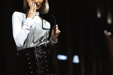 sürpriz genç kadının sokakta fener ışığı altında geceleri güneş gözlüklü kırpılmış atış