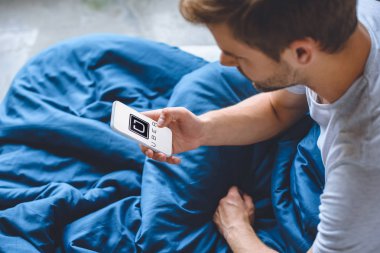 seçici odak gencin uber üstünde perde smartphone kullanarak yatakta 