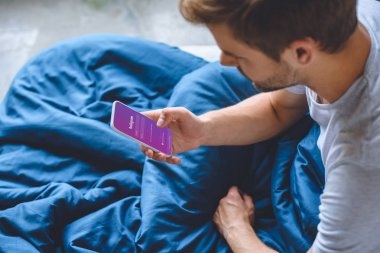 seçici odak gencin instagram üstünde perde smartphone kullanarak yatakta 