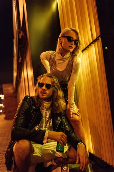 年轻迷人的夫妇穿着时髦的衣服在夜街下黄灯 — 图库照片
