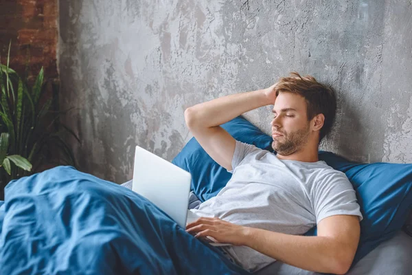 Upprörd Ung Man Använder Laptop Sängen Hemma — Stockfoto