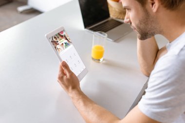 delikanlı suyu ve dijital tablet ile oturaklı ekranda kullanarak dizüstü bilgisayar ile mutfak masasında