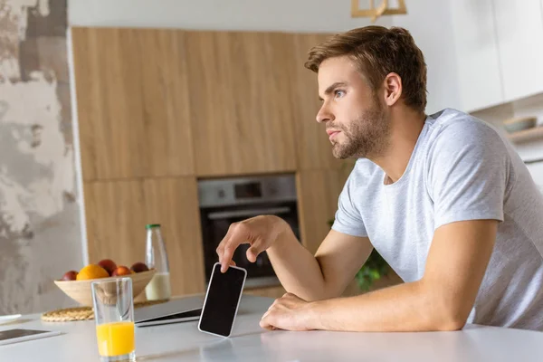 Pensativo Joven Con Teléfono Inteligente Sentado Mesa Cocina Con Vaso — Foto de stock gratis