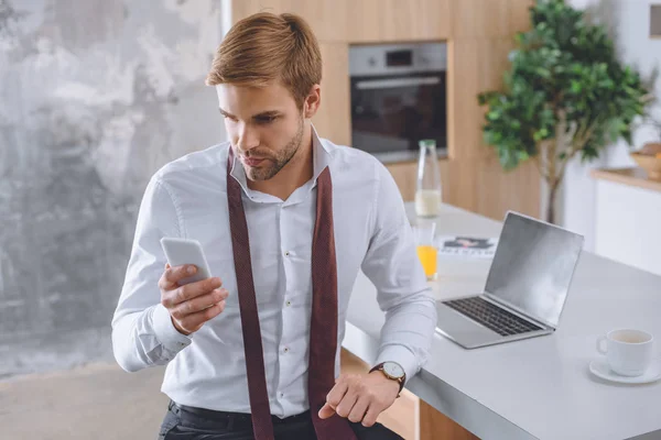 Kahve Fincanı Laptop Ile Mutfak Masasında Smartphone Kullanarak Adamı — Stok fotoğraf