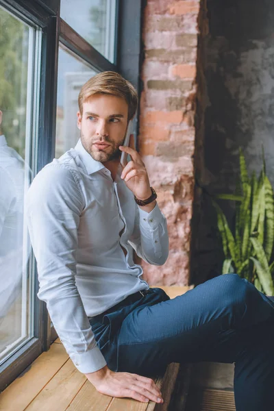 Joven Hombre Negocios Hablando Teléfono Inteligente Alféizar Ventana Casa — Foto de Stock