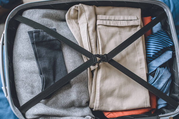 elevated view of clothes in traveler suitcase 